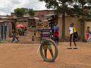 A child plays with a tire in a street in a slum on the outskirts of Kigali, Rwanda, in a file photo from 2019. Providing tablets for education in Third World countries would have big pay-offs in terms of helping to end poverty. 