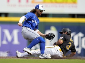 Pittsburgh Pirates' Ji Hwan Bae steals second base as Toronto Blue Jays shortstop Bo Bichette, left, waits for the throw in the third inning of a spring training baseball game Tuesday, March 5, 2024, in Bradenton, Fla.