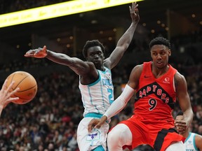 Toronto Raptors guard RJ Barrett (9) makes a pass as Charlotte Hornets forward Grant Williams (2) defends during second half NBA basketball action in Toronto on Sunday, March 3, 2024.