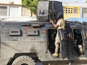 Police take cover during an anti-gang operation in Port-au-Prince