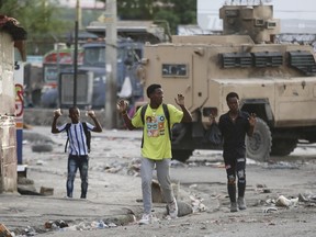 Youths raise their hands to show police