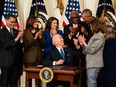 Former president Barack Obama, House Speaker Nancy Pelosi (D-Calif.) and other Democratic leaders surround President Biden as he signs an executive order strengthening the ACA in 2022.