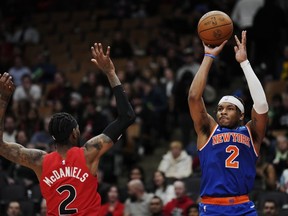 New York Knicks guard Miles McBride (right) shoots over Toronto Raptors forward Jalen McDaniels during second half NBA basketball action in Toronto on Wednesday, March 27, 2024.