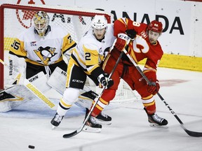 Pittsburgh Penguins defenceman Chad Ruhwedel (2) keeps Calgary Flames forward Andrew Mangiapane (88) away from goalie Tristan Jarry (35) during second period NHL hockey action in Calgary, Saturday, March 2, 2024.