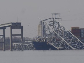 A container ship rests against wreckage of the Francis Scott Key Bridge on Tuesday, March 26, 2024, as seen from Sparrows Point, Md. The ship rammed into the major bridge in Baltimore early Tuesday, causing it to collapse in a matter of seconds and creating a terrifying scene as several vehicles plunged into the chilly river below.