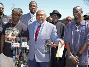 Michael Corey Jenkins, right, and Eddie Terrell Parker, left, stand with their local attorney Trent Walker, as he calls on a federal judge at a news conference Monday, March 18, 2024, in Jackson, Miss., to impose the harshest possible penalties against six former Mississippi Rankin County law enforcement officers who committed numerous acts of racially motivated, violent torture on them in 2023. The six former law officers pleaded guilty to a number of charges for torturing them and sentencing for them starts on Tuesday.
