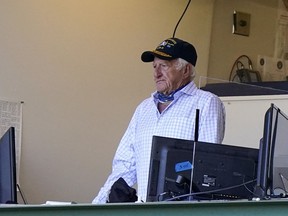 FILE - Milwaukee Brewers broadcaster Bob Uecker stands during the seventh inning of the team's baseball game against the Pittsburgh Pirates on Aug. 30, 2020, in Milwaukee. Uecker will be back behind the microphone when the Brewers play their home-opener Tuesday, April 3, against the Minnesota Twins. How heavy a broadcasting workload the 90-year-old Uecker will have the rest of the season remains uncertain.