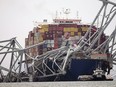 FILE - A cargo ship is stuck under the part of the structure of the Francis Scott Key Bridge after the ship hit the bridge Wednesday, March 27, 2024, in Baltimore, Md. On Thursday, March 28, The Associated Press reported on stories circulating online incorrectly claiming the captain of Dali, the container ship that crashed into Baltimore's Francis Scott Key Bridge, is Ukrainian.