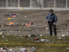 FILE - A law enforcement officer looks around the scene following a shooting at the Kansas City Chiefs NFL football Super Bowl celebration in Kansas City, Mo., Feb. 14, 2024. Kansas City, Missouri is preparing for its annual St. Patrick's Day parade on Sunday, March 17, 2024. It will be the first big mass gathering in Kansas City since Feb. 14, when gunfire erupted as about 1 million people attended a rally celebrating the Chiefs' Super Bowl win. Organizers say extra police will be on hand Sunday, along with many other precautions.