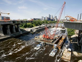 FILE - A section of the new I-35 bridge is raised from a barge in the foaming Mississippi River at Minneapolis, June 24, 2008. The I-35W bridge was rebuilt in less than 14 months. Experts say the rebuilding of Baltimore's Francis Scott Key Bridge likely will take longer, with estimates ranging from 18 months to several years.
