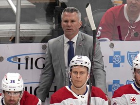 Montreal Canadiens head coach Martin St-Louis stands behind his bench during the first period of an NHL hockey game against the Pittsburgh Penguins in Pittsburgh, Thursday, Feb. 22, 2024.