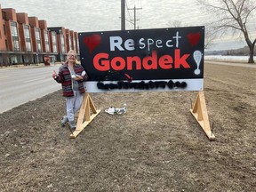 Karen Motyka and her friend painted 'Respect Gondek' over a Recall Gondek sign on Tuesday.