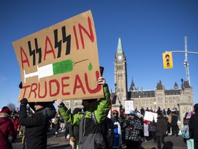 People protest Prime Minister Justin Trudeau and vaccinations during a rally against COVID-19 restrictions on Parliament Hill, Saturday, Jan. 29, 2022.
