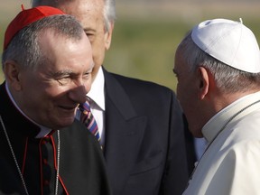 FILE - Pope Francis greets Vatican Secretary of State Monsignor Pietro Parolin, left, as he arrives to board a plane to Amman, Jordan, for a three-day trip to the Middle East including the West Bank and Israel, at Rome's Fiumicino international airport, Saturday, May 24, 2014. The Vatican secretary of state is trying to defuse Pope Francis' latest diplomatic kerfluffle, insisting in media interviews that a primary condition for negotiations to end the war in Ukraine is an end to Russia's aggression and that any peace must be a "just peace."