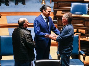 Manitoba Premier Wab Kinew, centre, apologizes to Richard Beauvais, right, and Edward Ambrose, left, who were switched at birth in 1955, in the Manitoba Legislature in Winnipeg, Manitoba Thursday, March 21, 2014.