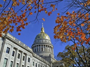 FILE - This Nov. 3, 2014 file photo shows the West Virginia Capitol with its dome framed by turning sugar maples leaves in Charleston, W.Va. West Virginia's unemployed workers will need to do more to prove they are searching for jobs to collect state benefits under a new law that will take effect next year.