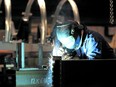 A welder is seen working in a factory in Quebec City.