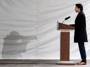 Broadcast lighting casts the shadow of a news photographer on the wall of the tent as Prime Minister Justin Trudeau speaks during his daily press conference on the COVID-19 pandemic at his residence at Rideau Cottage in Ottawa, on Friday, April 24, 2020.