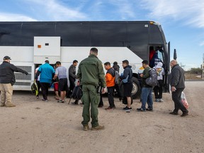 Immigrants file into a U.S. Customs and Border Protection bus after crossing the U.S.-Mexico border in Eagle Pass, Texas. Since 2022, thousands of migrants have been bused north from Texas to "sanctuary cities" like Denver or New York; both of which have attempted to redirect the migrants even further north into Canada.