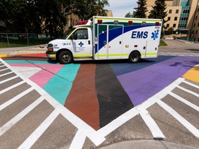 An AHS ambulance crew drive through the new Progress Pride crosswalk outside of Royal Alexandra Hospital in Edmonton, on June 28, 2022. The flag was painted by AHS staff to celebrate the LGBTQ2S+ community and their allies.