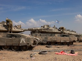 Israeli soldiers work on their tanks