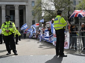 Pro-Israel counter protestors wave flags as pro-Palestinian activists and supporters take part in a protest march in central London, during a National Day of Action calling for a ceasefire in the Israel-Hamas war, on April 13, 2024.