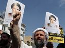 An Iranian Shiite Muslim cleric raises a clenched fist as others carry pictures of Iran's late supreme leader Ayatollah Ruhollah Khomeini, during an anti-Israel demonstration after the Friday noon prayer in Tehran on April 19, 2024. (Photo by ATTA KENARE/AFP via Getty Images)