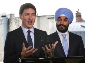 Canadian Prime Minister Justin Trudeau (L) delivers a press conference flanked by Canadian Minister of Innovation, Science and Economic Development Navdeep Singh Bains (R) on May 16, 2019, in Paris.