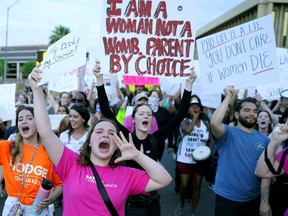 Protesters in Phoenix shout as they join thousands marching around the Arizona state Capitol after the U.S. Supreme Court decision to overturn the landmark Roe v. Wade abortion decision on June 24, 2022.