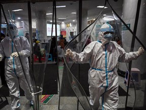Health workers wear hazmat suits at a Wuhan hospital.