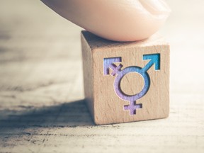 Transgender, LGBT or Intersex Icon On Wodden Block On A Table Arranged By A Finger