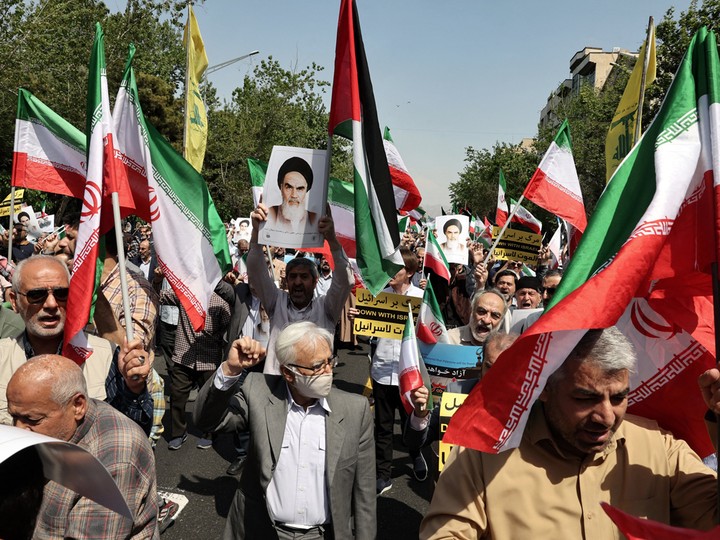  Iranian’s wave the flags of Palestine and Iran they gather during an anti-Israel demonstration after the Friday noon prayer in Tehran on April 19, 2024.