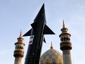 A model of a missile is carried by Iranian demonstrators as minarets and dome of a mosque is seen at background during an anti-Israeli gathering at the Felestin (Palestine) Sq. in Tehran, Iran, Monday, April 15, 2024.