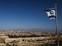 La bandera israelí ondea en el Monte de los Olivos, con vistas al horizonte de Jerusalén, el 19 de abril de 2024.