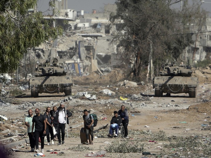  Palestinians flee to northern Gaza as Israeli tanks block a road in the central Gaza Strip on Nov. 24, 2023.