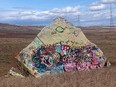 A large boulder covered with graffiti.