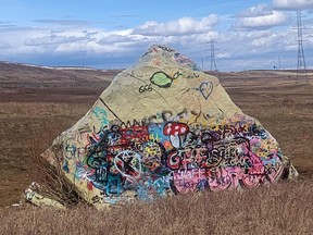 A large boulder covered with graffiti.
