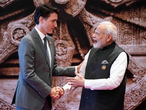 Justin Trudeau and Narendra Modi shake hands.
