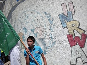 A Palestinian boy holds a Hamas flag outside the UNRWA Gaza headquarters.