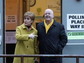 FILE - Scottish First Minister Nicola Sturgeon poses for the media with husband Peter Murrell, outside polling station in Glasgow, Scotland, on Dec. 12, 2019. The husband of former Scottish First Minister Nicola Sturgeon has been re-arrested in a probe into the finances of Scotland's pro-independence governing party. Police Scotland said a 59-year-old man had been taken into custody on Thursday, April 18, 2024 and was being questioned by detectives. While police did not name the suspect, the details provided matched up with Peter Murrell, the party's ex-chief executive who was first arrested over a year ago.