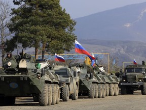FILE - Russian peacekeepers' vehicles are parked at a checkpoint on the road to Shusha in the separatist region of Nagorno-Karabakh, on Tuesday, Nov. 17, 2020. President Vladimir Putin's spokesman said Wednesday April 17, 2024 that Russian forces are being withdrawn from Azerbaijan's Karabakh region, where they have been stationed as peacekeepers since the end of a war in 2020.