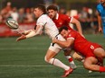 Team USA's Steve Tomasin passes the ball off as Team Canada's Elias Ergas during the men's gold medal match at the Rugby Sevens Paris 2024 Olympic qualification event at Starlight Stadium in Langford, B.C., on Sunday, August 20, 2023.