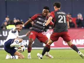 Simcoe County Rovers' Alejandro Portal, left, battles for the ball with Toronto FC's Cassius Mailula and Jonathan Osorio during first half Canadian Championship soccer action, in Toronto, Wednesday, April 24, 2024.