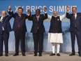 From left: Brazil's President Luiz Inacio Lula da Silva, China's President Xi Jinping, South African President Cyril Ramaphosa, Indian Prime Minister Narendra Modi and Russia's Foreign Minister Sergei Lavrov raise their arms as they pose for a group photograph, at the BRICS Summit in Johannesburg on August 23, 2023.