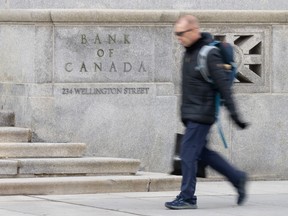 A person walks past the Bank of Canada, Wednesday, April 10, 2024 in Ottawa. Canada has so far averted a recession that many economists feared would happen after the Bank of Canada began its aggressive rate-hiking cycle.