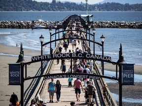 People walk on the pier in White Rock, B.C., on Sunday, June 28, 2020.