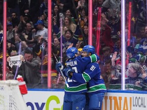 Vancouver Canucks' Dakota Joshua, right, and Elias Lindholm celebrate Joshua's goal against the Calgary Flames during the second period of an NHL hockey game in Vancouver, on Tuesday, April 16, 2024.