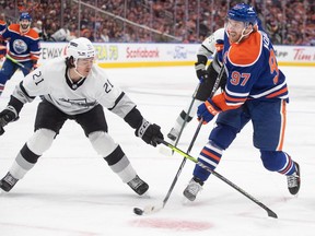 Los Angeles Kings' Jordan Spence (21) tries to stop Edmonton Oilers' Connor McDavid during second period of Game 1 first round NHL Stanley Cup playoff hockey action in Edmonton, Monday, April 22, 2024.
