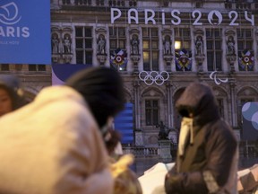 Migrants stand in front of the Paris City Hall