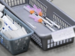 A basket of needles containing COVID-19 vaccines waits to be administered to patients at a COVID-19 clinic in Ottawa on March 30, 2021.